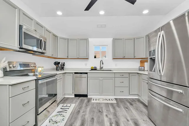 a kitchen with a sink window and stainless steel appliances