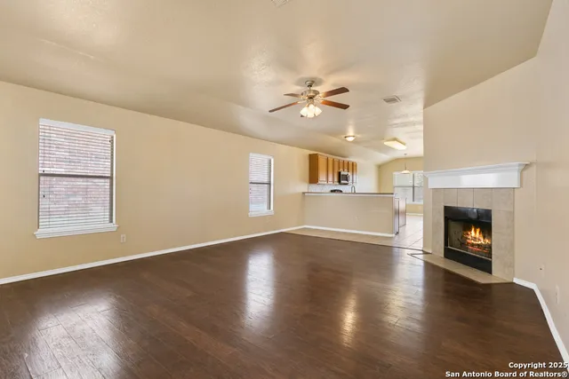 a view of empty room with wooden floor and fireplace