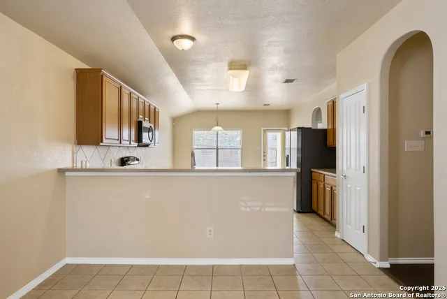 a view of a kitchen with a sink refrigerator and wooden floor