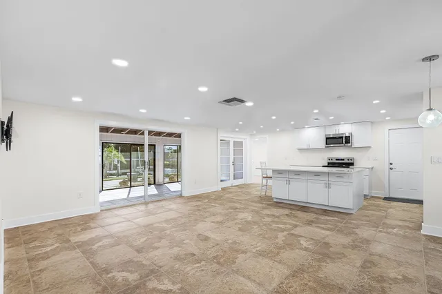 a large kitchen with kitchen island a sink a stove and a refrigerator with wooden floor