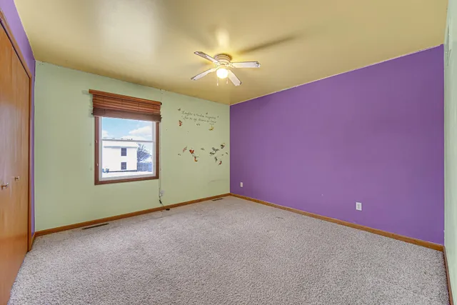an empty room with fan and window