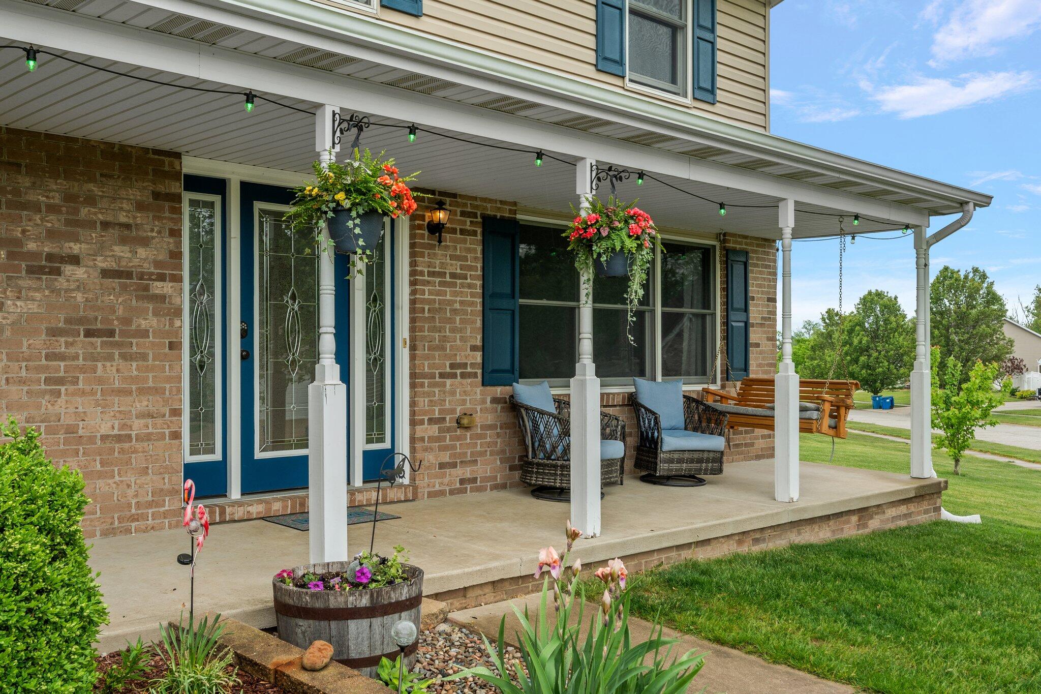 515 Tamarack Trail Hebron, IN 46341 - Photo 32 of 38 a front view of a house with a porch and potted plants