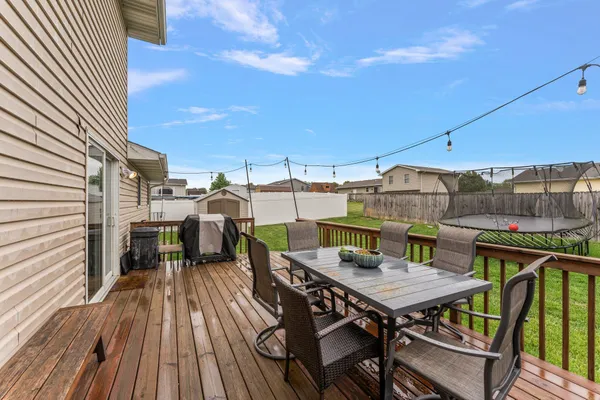a view of a roof deck with table and chairs
