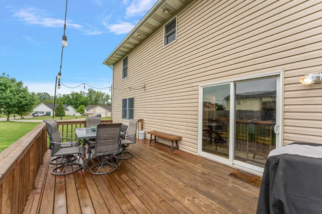 a view of a roof deck with table and chairs floor to ceiling window with wooden floor