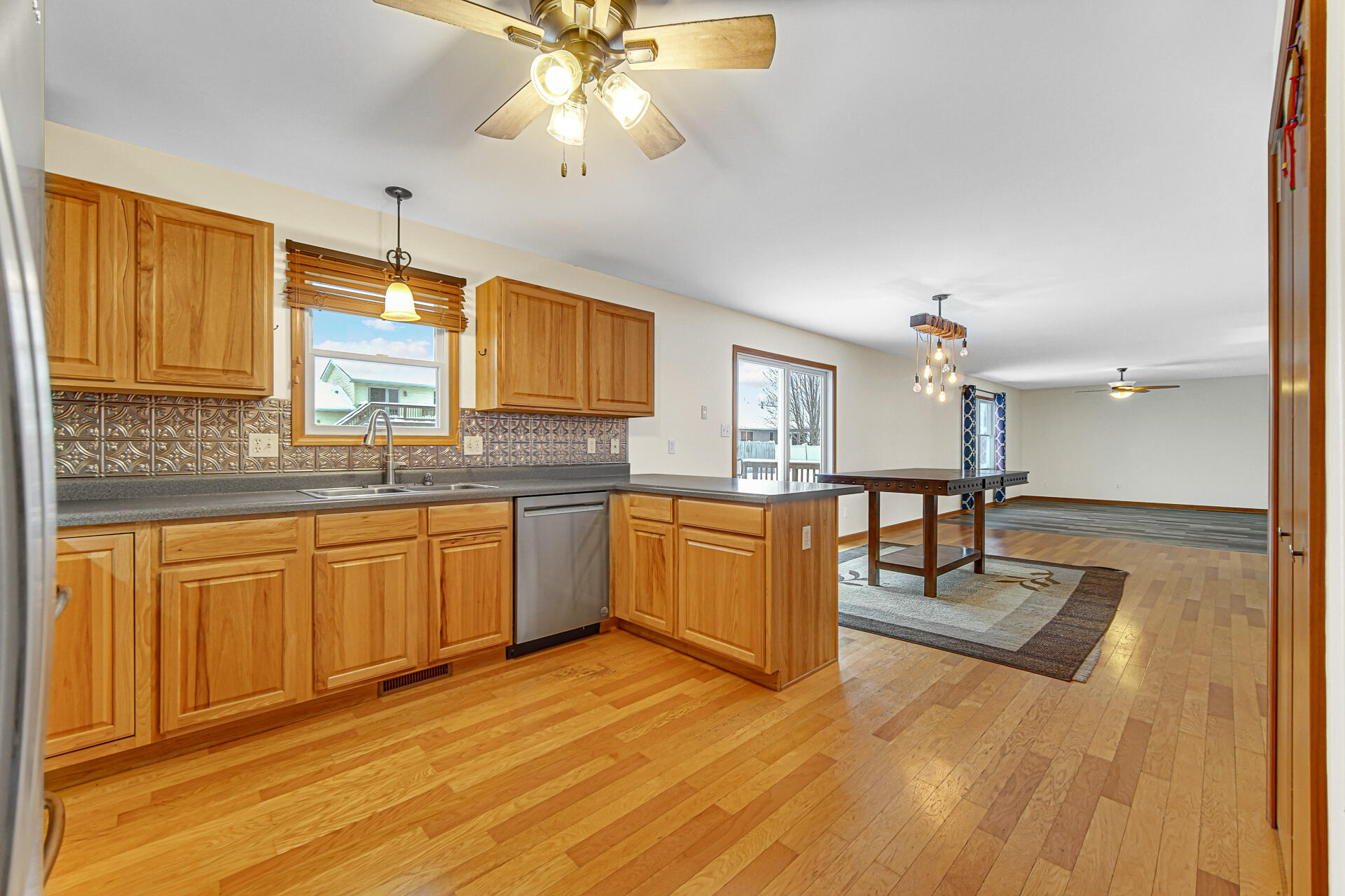 515 Tamarack Trail Hebron, IN 46341 - Photo 7 of 38 a large kitchen with stainless steel appliances granite countertop a stove a sink dishwasher and a microwave oven with wooden floor