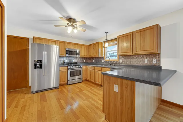 a kitchen with granite countertop stainless steel appliances cabinets a sink and a counter top space