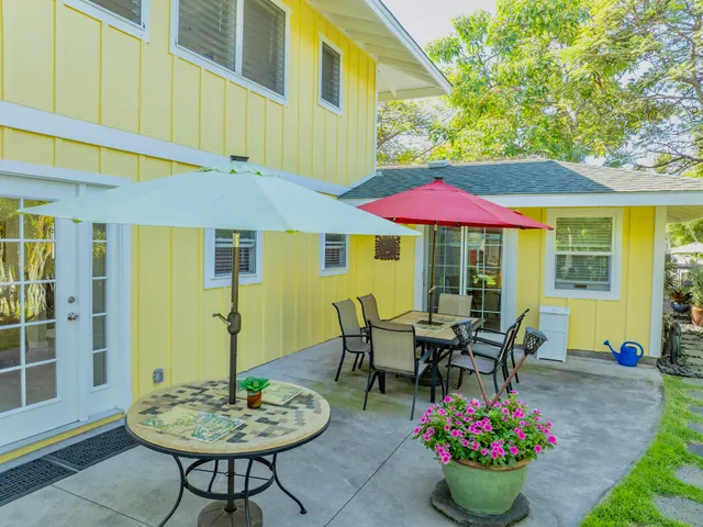 a view of a patio with a table and chairs under an umbrella