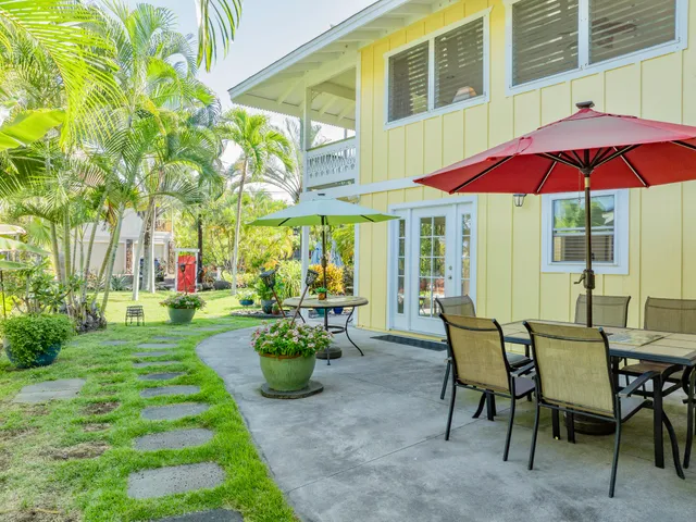 a view of a house with backyard and sitting area
