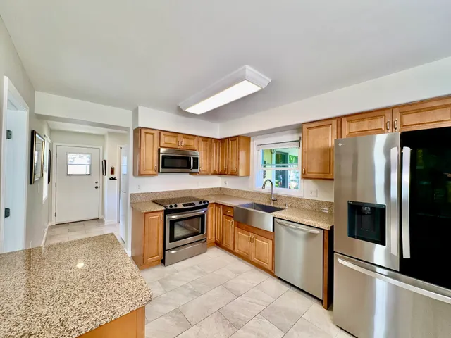 a large kitchen with cabinets and stainless steel appliances