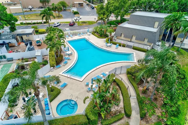 an aerial view of a swimming pool with outdoor seating and yard