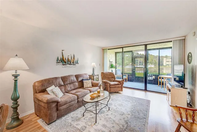 a living room with furniture and a large window with balcony view