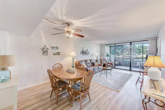 a view of a dining room with furniture a chandelier and wooden floor