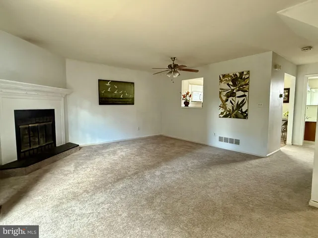 an empty room with windows and fireplace