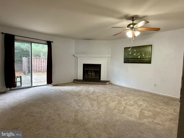 a view of a livingroom with a ceiling fan and window