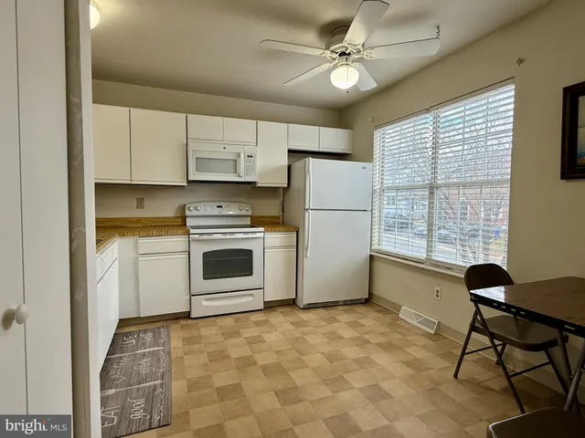 a kitchen with a stove a refrigerator and cabinets