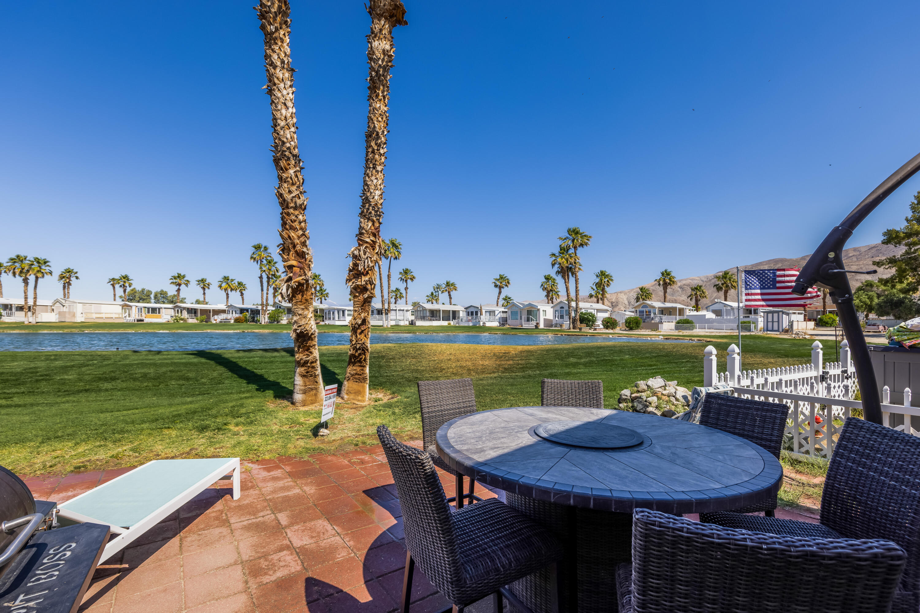 74711 Dillon Road, Unit 123 Sky Valley, CA 92241 - Photo 16 of 23 a view of a lake with couches chairs and a table