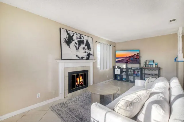 a living room with furniture a fireplace and a flat screen tv