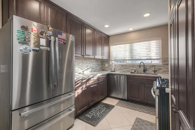 a kitchen with granite countertop a refrigerator and a sink