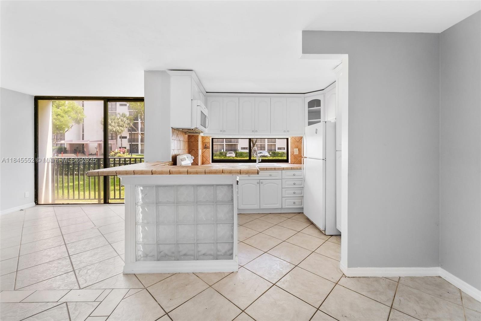 16919 North Bay Road, Unit 115 Sunny Isles Beach, FL 33160 - Photo 12 of 20 a view of a kitchen with furniture and a window