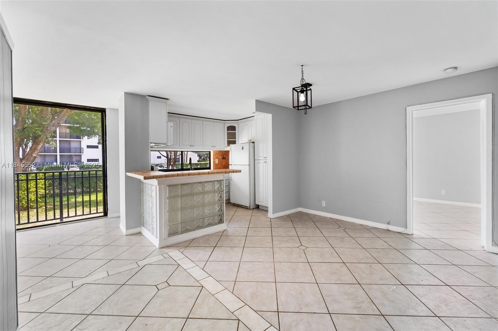 16919 North Bay Road, Unit 115 Sunny Isles Beach, FL 33160 - Photo 10 of 20 a kitchen with granite countertop a refrigerator and a stove top oven