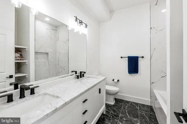 a bathroom with a double vanity sink toilet and shower