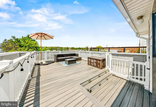 a view of a balcony with wooden floor and seating space
