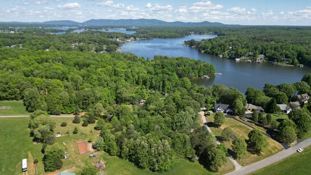 an aerial view of a houses with a yard and lake view
