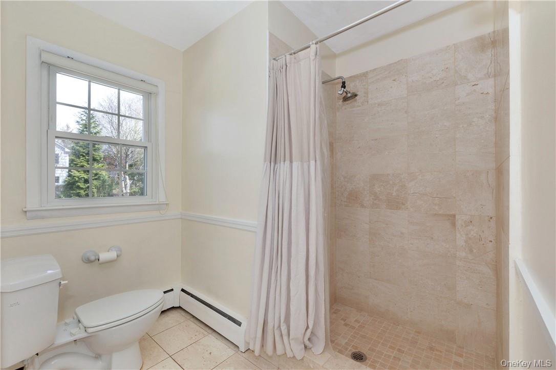 3 Lea Place Rye, NY 10580 - Photo 14 of 32 a bathroom with a granite countertop shower a toilet and a window