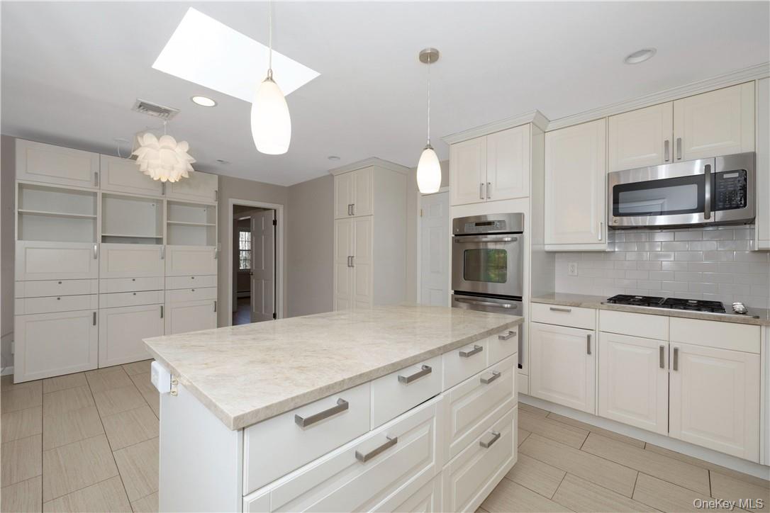 3 Lea Place Rye, NY 10580 - Photo 8 of 32 a kitchen with white cabinets and stainless steel appliances