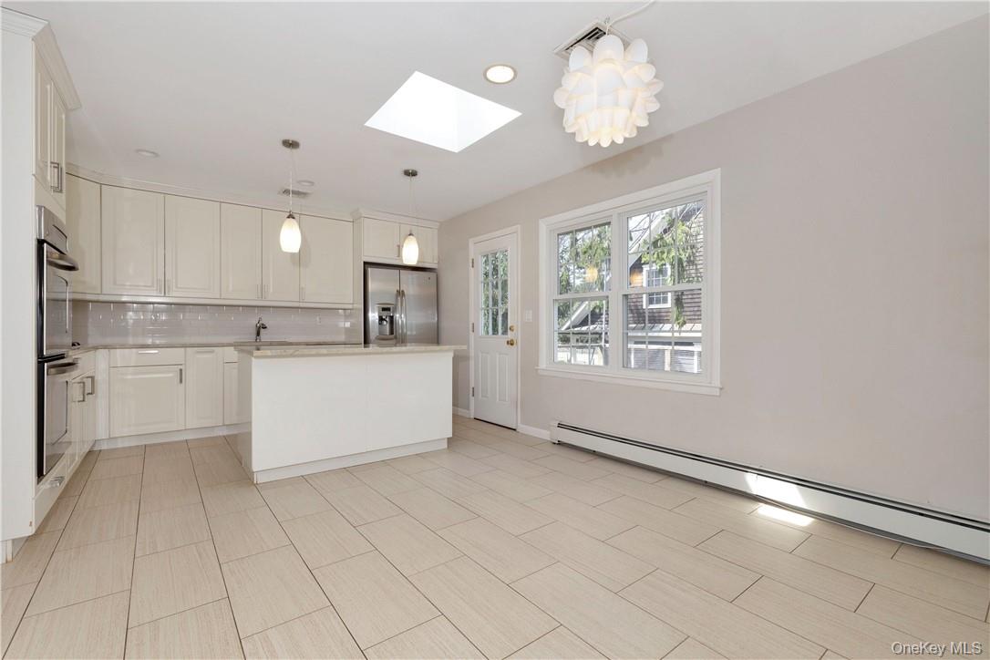 3 Lea Place Rye, NY 10580 - Photo 9 of 32 a large white kitchen with cabinets and a chandelier