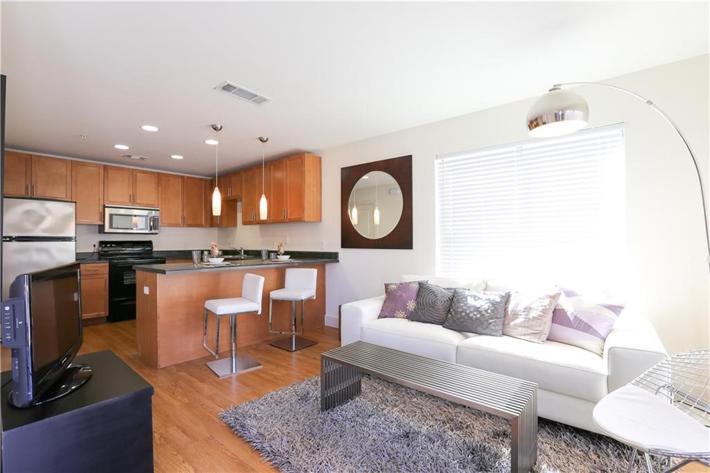 711 West 32nd Street, Unit 119 Austin, TX 78705 - Photo 1 of 23 a living room with kitchen view and a couch