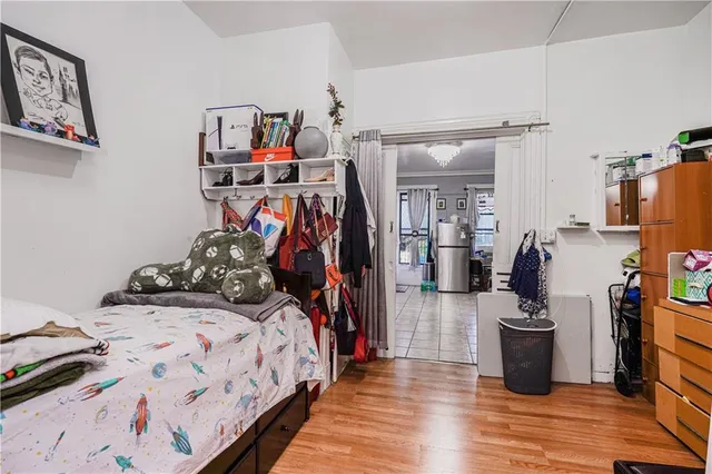 a view of a bedroom with baby bed and workspace