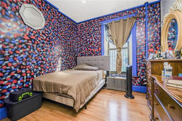 a bedroom with a bed and a painting on the wall