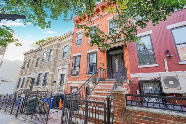 a front view of a building with glass windows and furniture