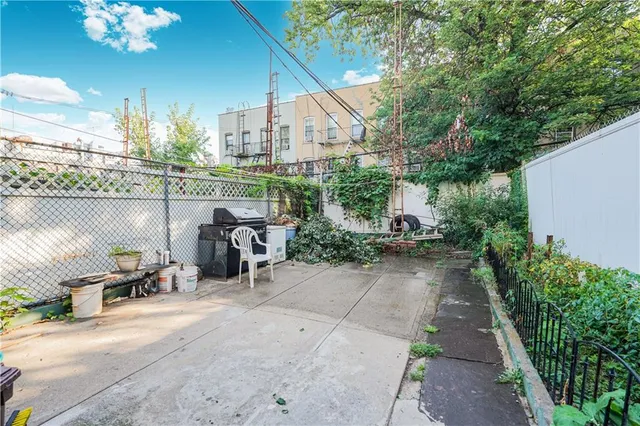 a view of a patio with dining table and chairs under an umbrella