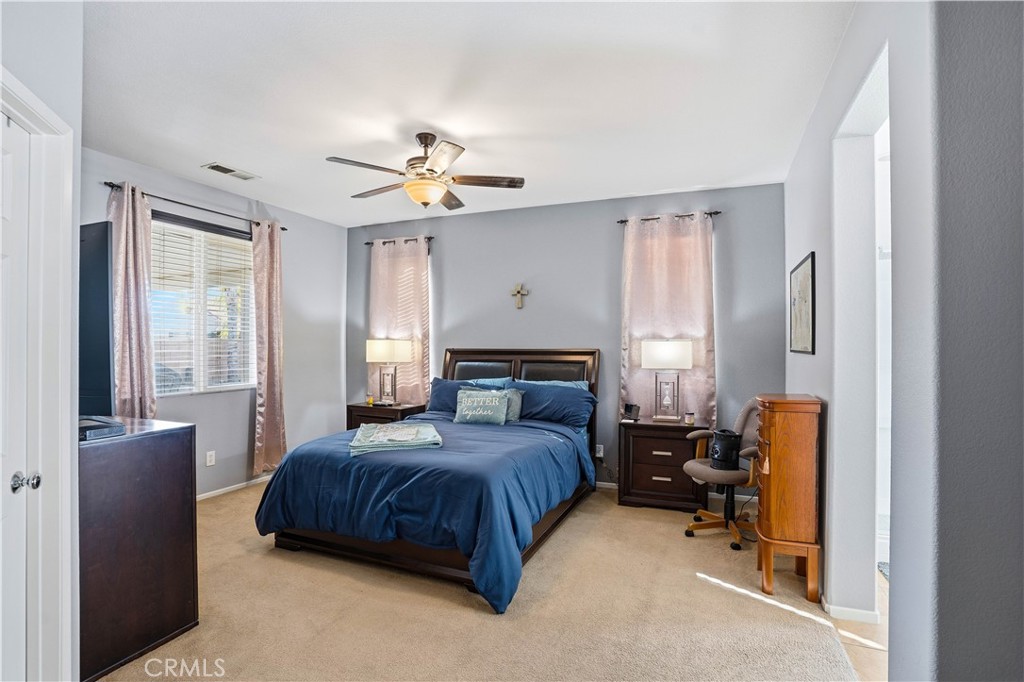 29183 Paperflower Lane Menifee, CA 92584 - Photo 24 of 49 a bedroom with a bed couch and a window