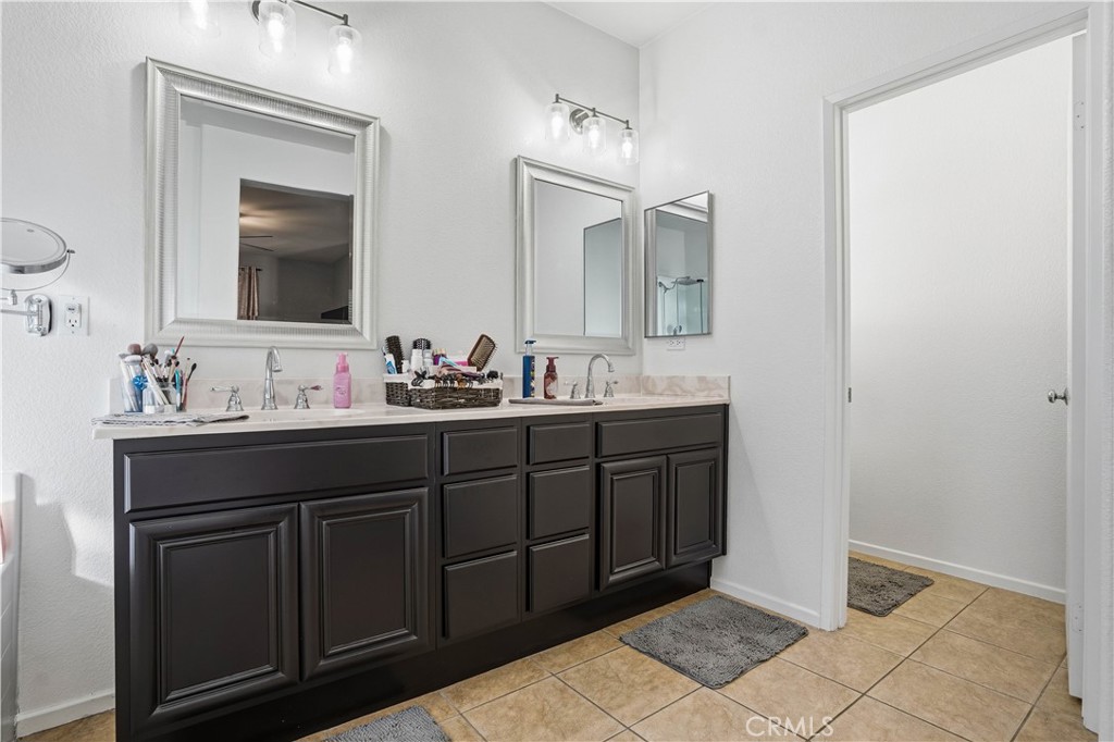 29183 Paperflower Lane Menifee, CA 92584 - Photo 27 of 49 a bathroom with a double vanity sink and mirror