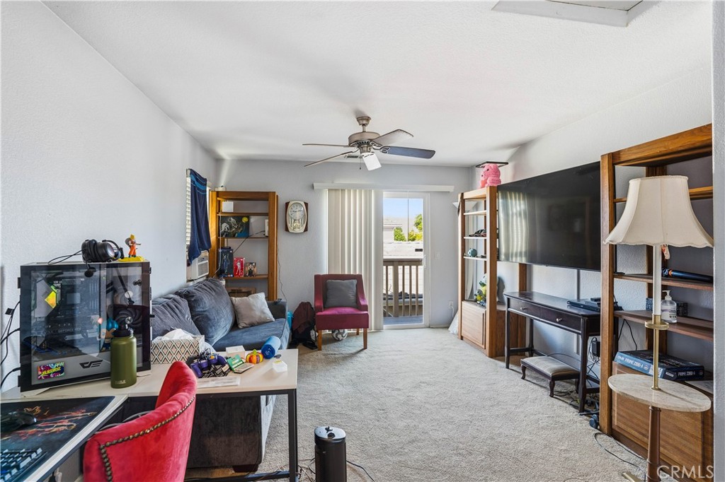 29183 Paperflower Lane Menifee, CA 92584 - Photo 30 of 49 a living room with furniture a flat screen tv and a book shelf