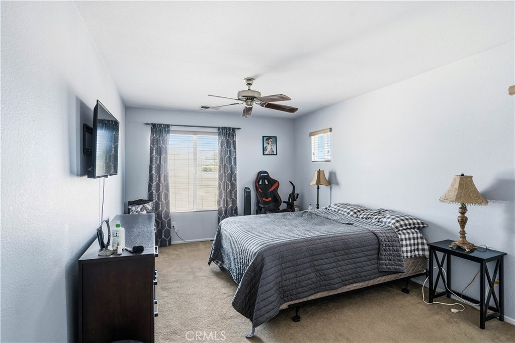 29183 Paperflower Lane Menifee, CA 92584 - Photo 32 of 49 a bedroom with a bed and a chandelier