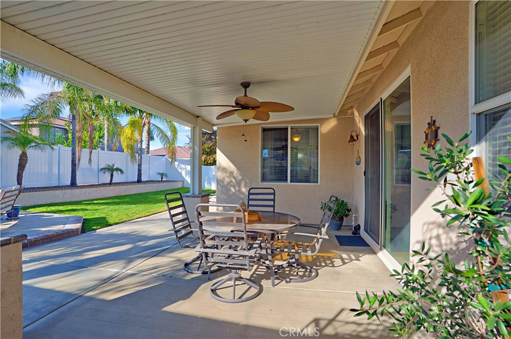 29183 Paperflower Lane Menifee, CA 92584 - Photo 37 of 49 a view of a patio with table and chairs potted plants and floor to ceiling window