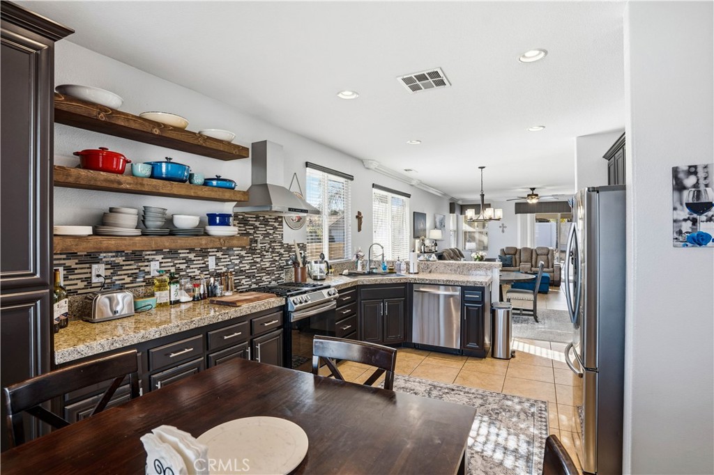 29183 Paperflower Lane Menifee, CA 92584 - Photo 8 of 49 a kitchen with stainless steel appliances kitchen island granite countertop lots of counter top space and furniture