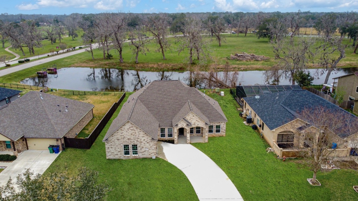 an aerial view of a house with garden space and a lake view