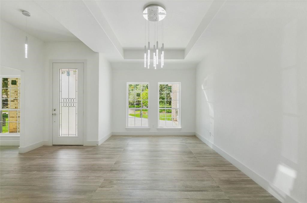 2291 Riverside Drive West Columbia, TX 77486 - Photo 20 of 50 an empty room with wooden floor chandelier and windows