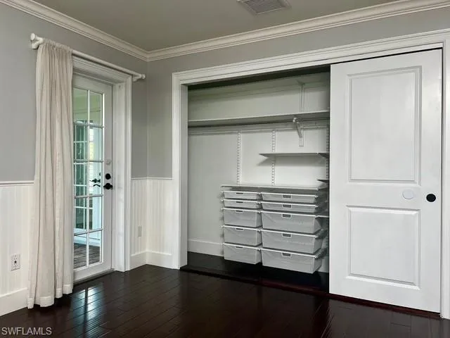 a room with walk in closet and wooden floor