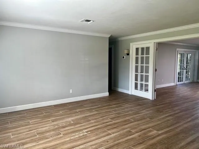 a view of an empty room with wooden floor