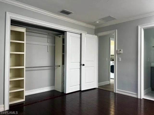 a view of an empty room with wooden floor & closet