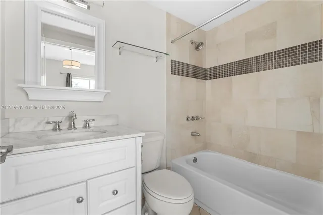 a bathroom with a granite countertop sink a toilet and shower