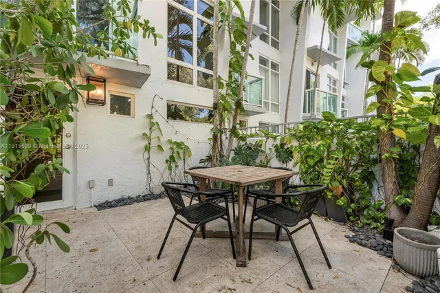 a view of a patio with table and chairs and potted plants