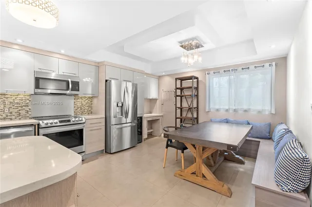 a kitchen with stainless steel appliances kitchen island granite countertop a sink refrigerator stove and microwave