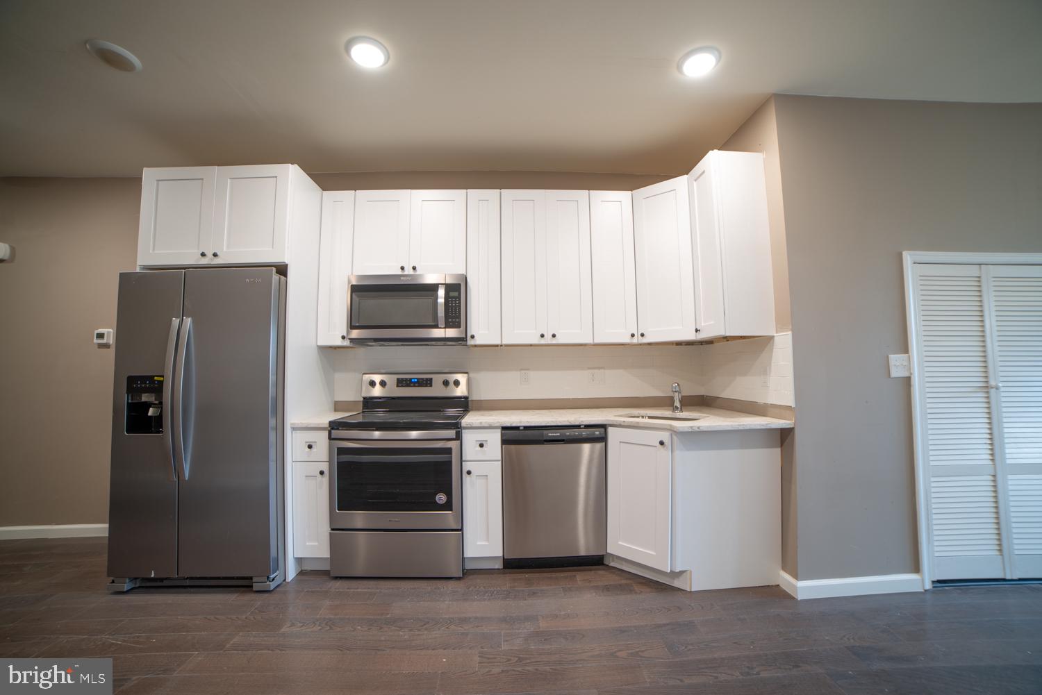 1848 North 16th Street, Unit 1 Philadelphia, PA 19121 - Photo 12 of 24 a kitchen with stainless steel appliances granite countertop a refrigerator stove and microwave